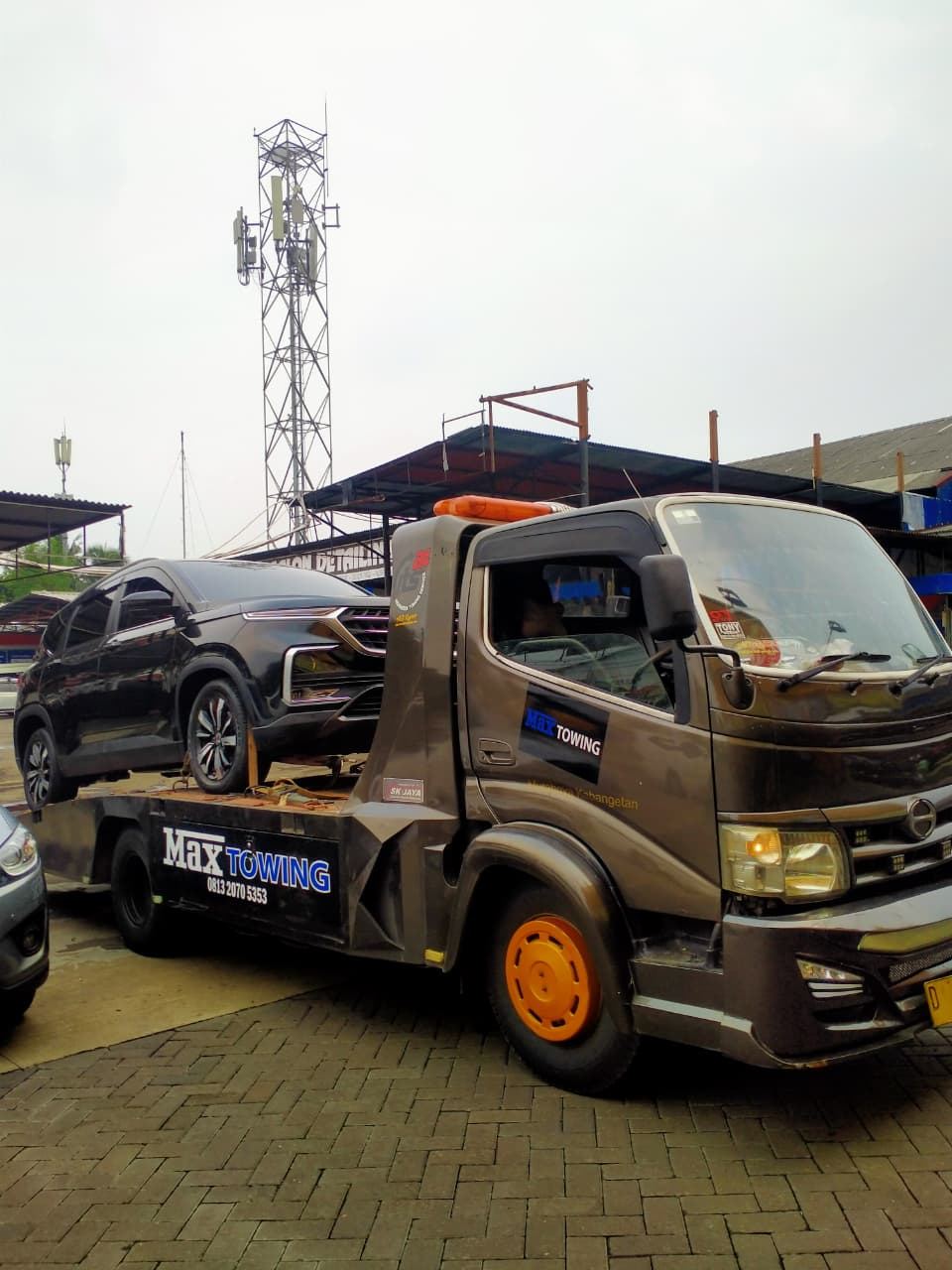 Truk Max Towing mengangkut SUV di area perumahan